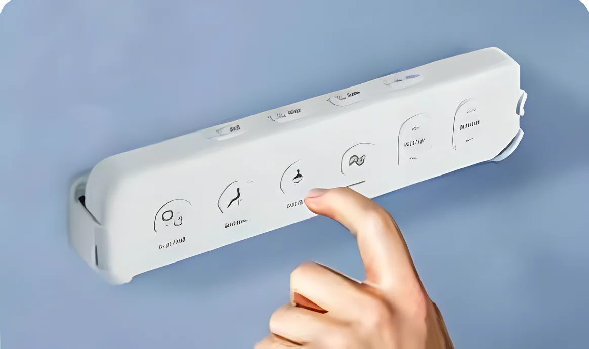 A finger pressing a button on the slim wall remote